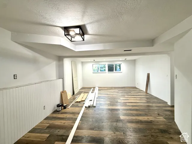 Wood-finish flooring, white paneled wall treatment, recessed lighting, and dual windows
