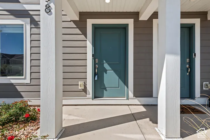 Siding exterior with a teal entry door, contrasting white trim, and a concrete entry pad
