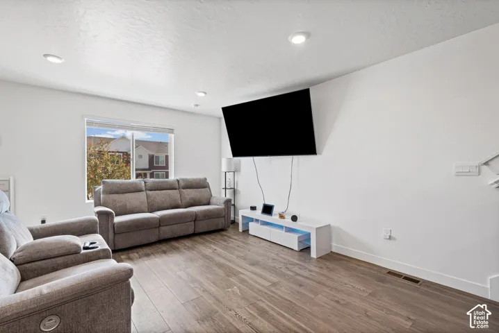 Recessed lighting, wood-finish flooring, and a large window