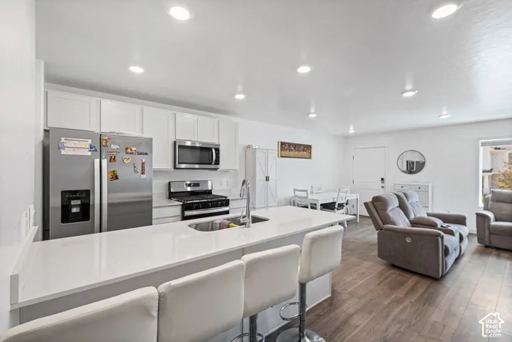 Kitchen with white cabinetry, stainless steel appliances, and a central island with a white countertop