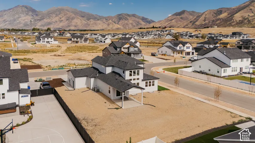 Newly constructed home featuring a two-story design with modern architectural detailing, dark roofing, and a spacious front-facing driveway