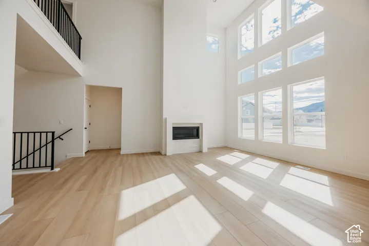 Vaulted ceilings, wood-finish flooring, and a contemporary fireplace with a tile surround