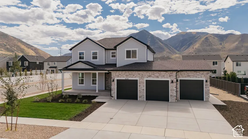 Modern two-story residence featuring a clean-lined exterior with mixed stone and siding finishes, gabled roofline, and multiple large windows