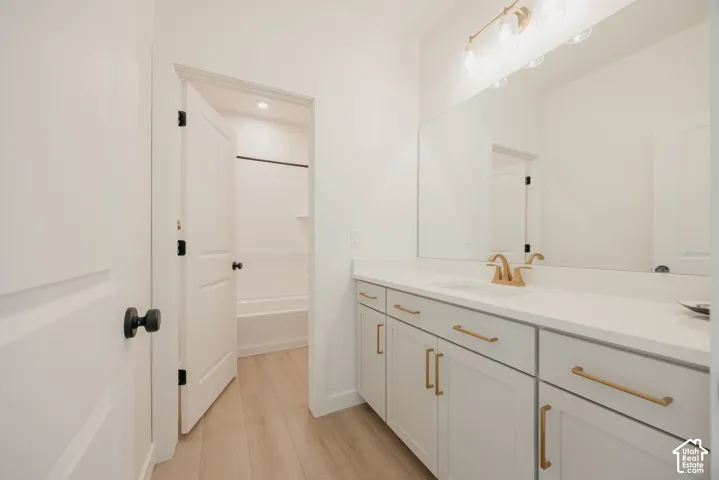 Double vanity with gold-tone hardware, undermount sink, and expansive mirror