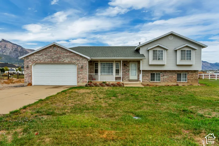 Stone and siding exterior with a two-car garage and a covered front porch