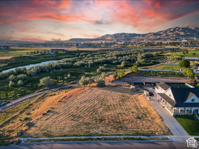 Expansive lot with mountain backdrop, established riverfront, and paved street frontage