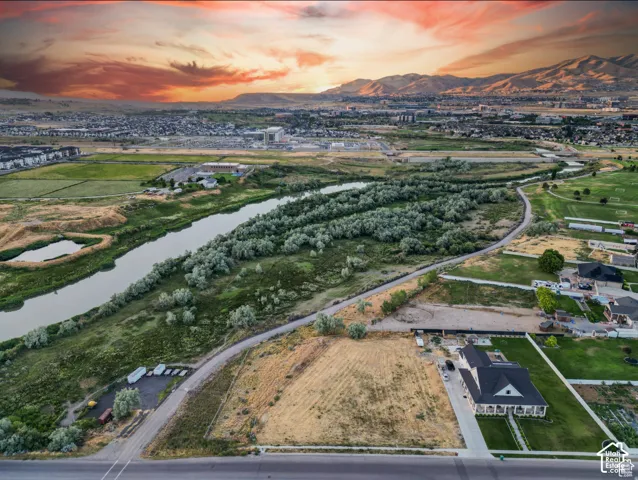 Expansive lot with established landscaping, featuring a river and mountainous backdrop