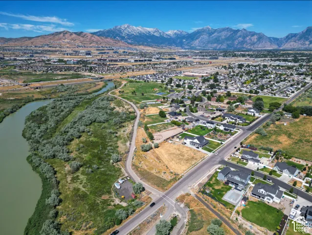 Expansive riverfront property with mature trees, established residential areas, and distant snow-capped mountains