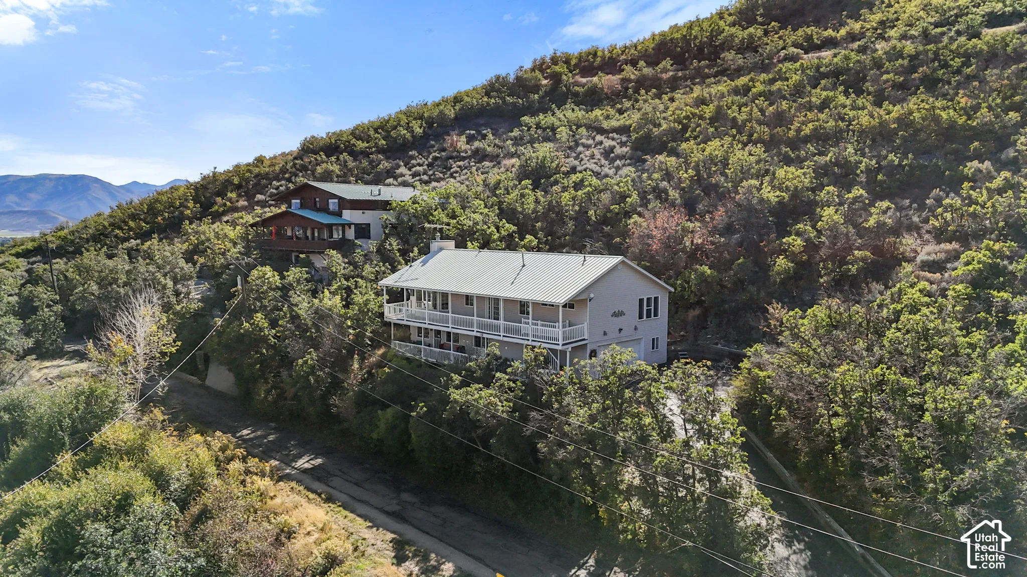 Two-story residence with a metal roof and light-colored siding