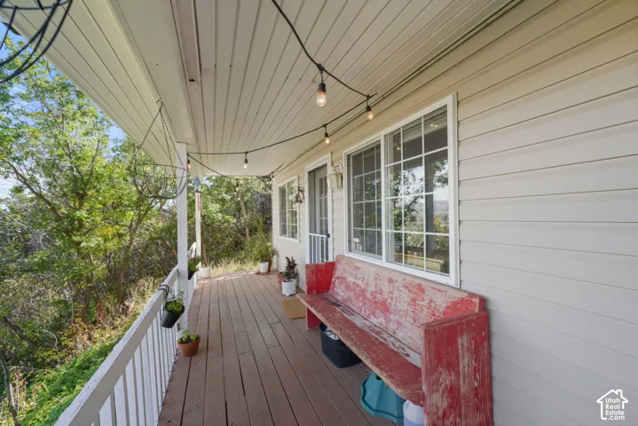Covered porch with wood-finish flooring, white railing