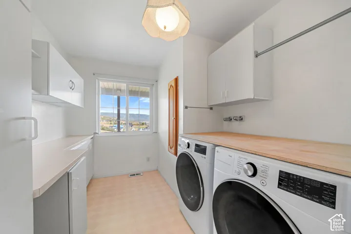 Utility room with light-colored flooring, white cabinetry, and a wood-finish countertop