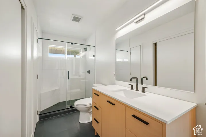 Glass-enclosed shower with a built-in bench, black-finish fixtures, and a window