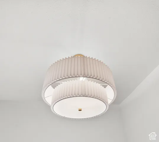 Tiered semi-flush mount light fixture with pleated fabric shades and brass accents