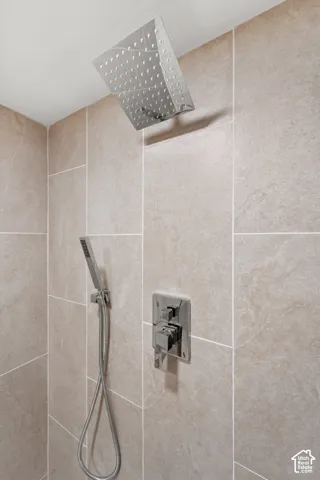 Rainfall showerhead, handheld shower, chrome fixtures, and large-format wall tiling