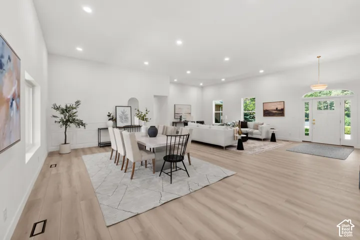 Expansive living area with wood-finish flooring, recessed lighting, and a prominent arched entryway