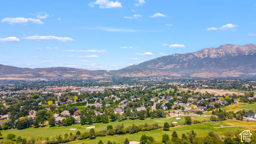 Expansive community with golf course frontage, mature landscaping, and mountain backdrop