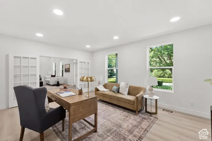 Recessed lighting, wood-finish flooring, and white walls create a bright interior