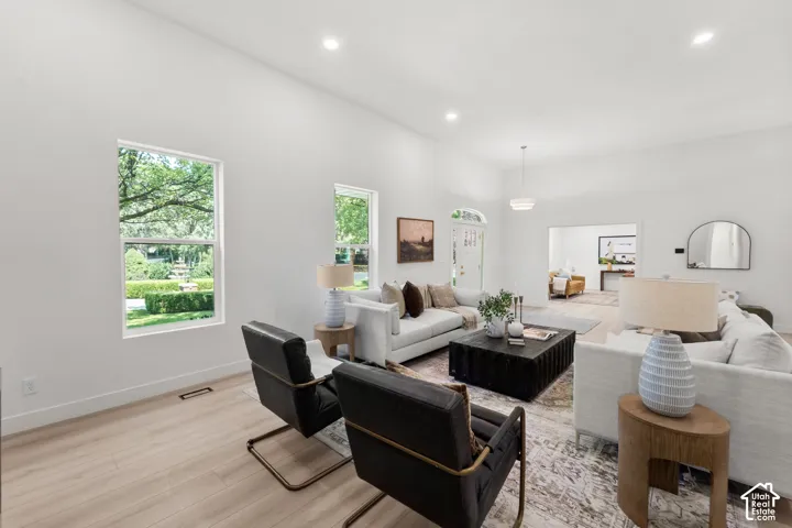 Spacious living area featuring light wood-finish flooring and recessed lighting