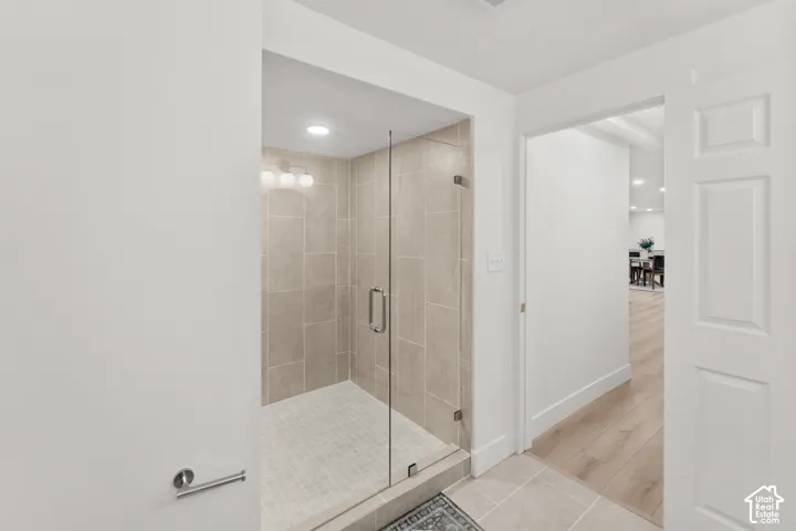 Walk-in shower featuring glass enclosure, tiled walls, and recessed lighting