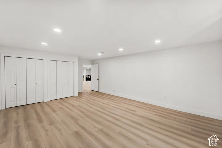 Wood-finish flooring, recessed lighting, and white walls