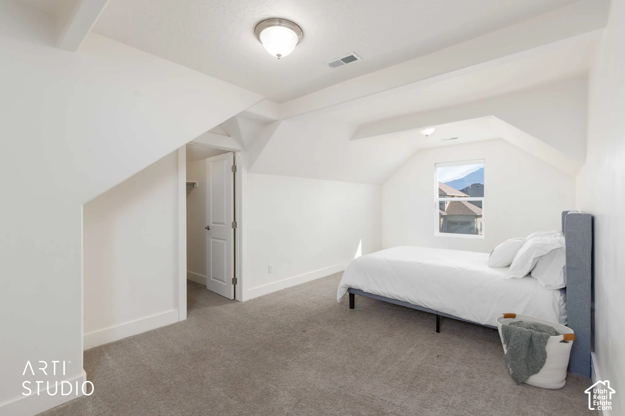 Vaulted ceilings with exposed beams, recessed lighting, and carpeted flooring