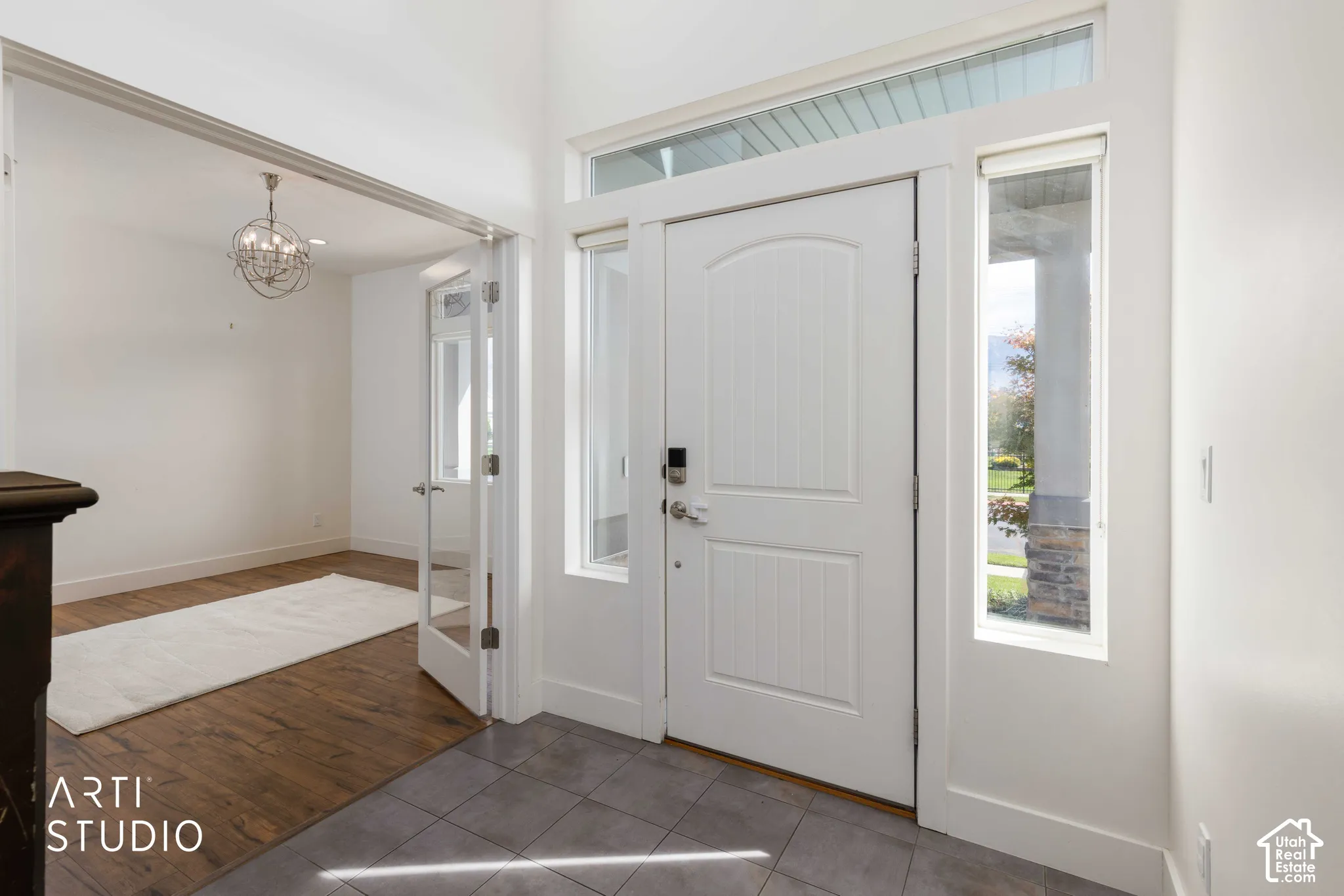 Entryway with tile flooring, a white paneled door, and a transom window