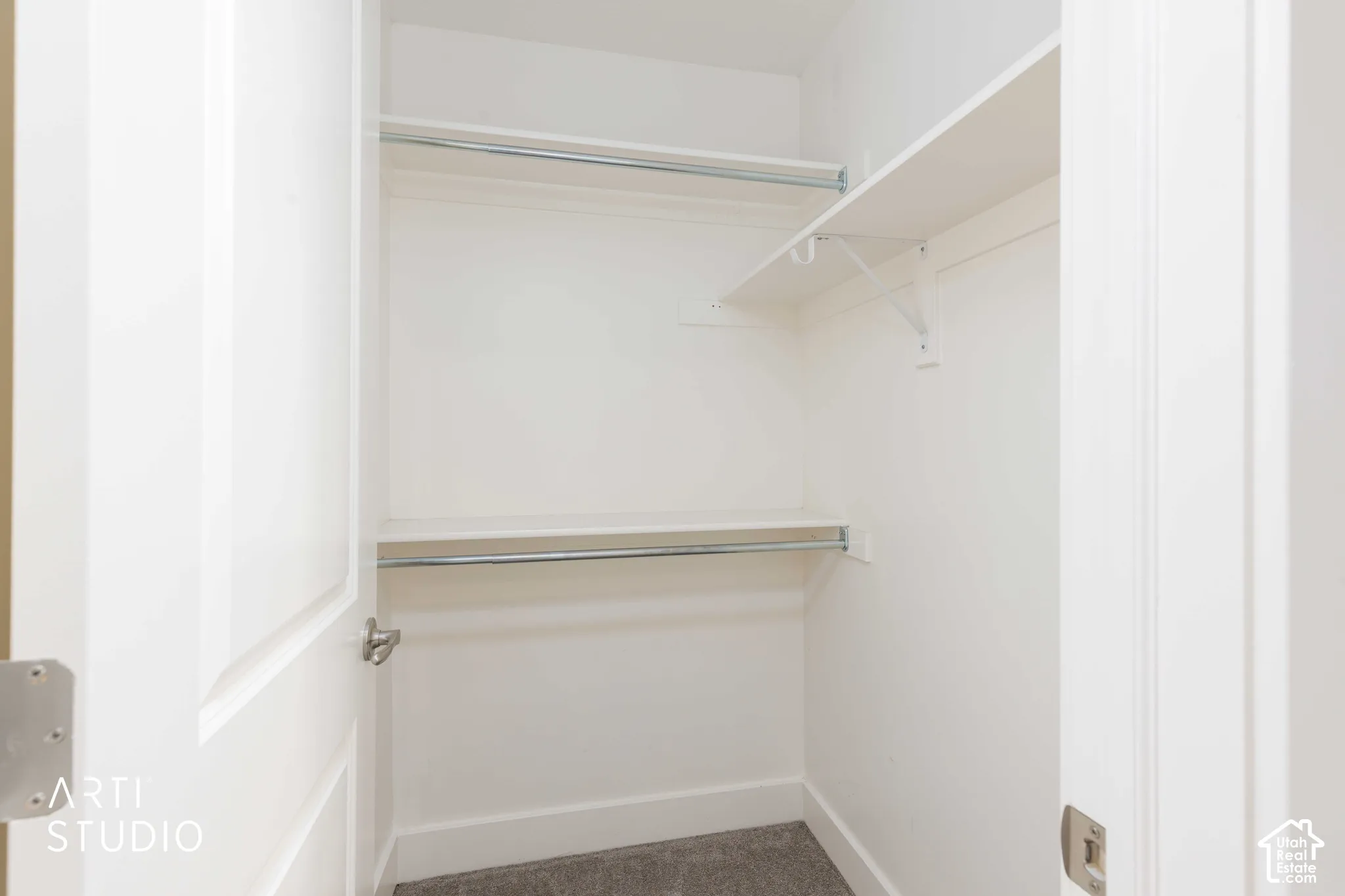 White painted interior with two shelving units and two clothing rods