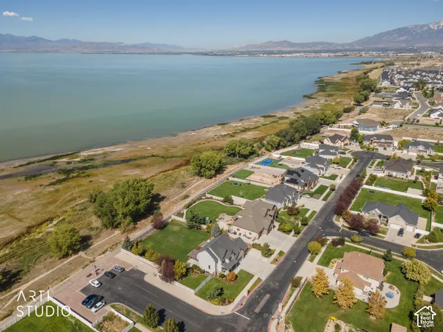 Expansive waterfront property with mountain backdrop, surrounded by residential development