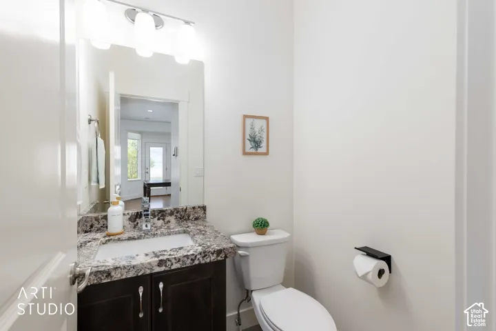 Vanity with a granite countertop, undermount sink, and dark wood-finish cabinetry