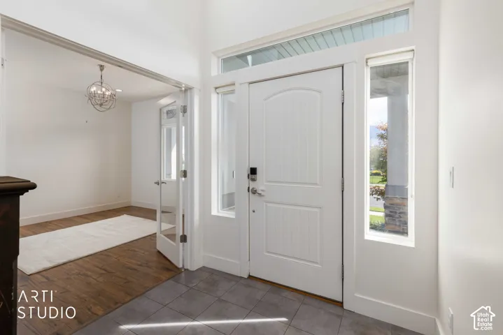 Entryway with tile flooring, a white paneled door, and a transom window