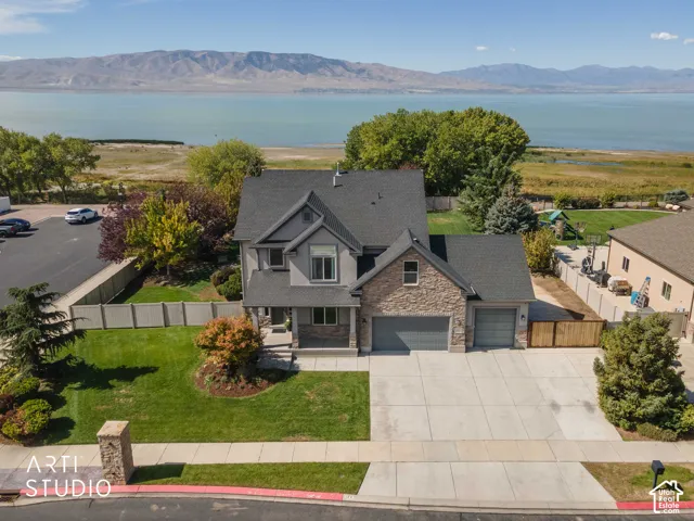 Two-story residence featuring a partial stone facade, an attached two-car garage, and a concrete driveway