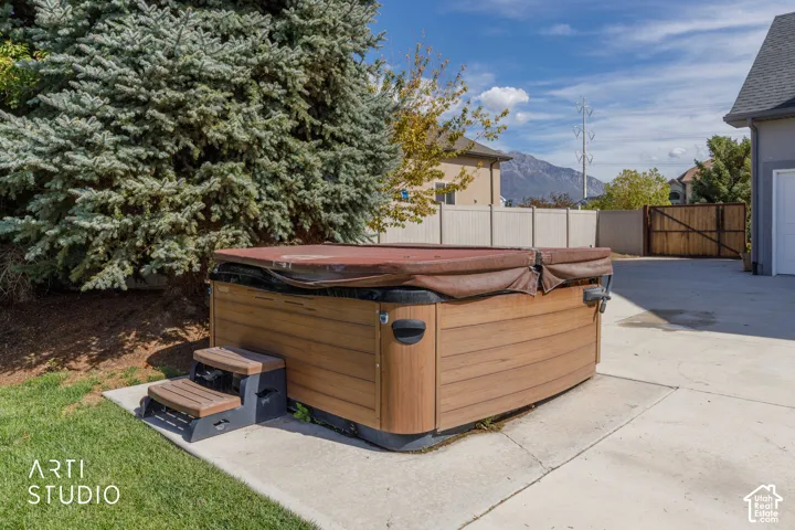 Outdoor spa with wood-finish siding, integrated steps, and a durable cover