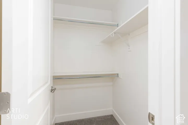 White painted interior with two shelving units and two clothing rods