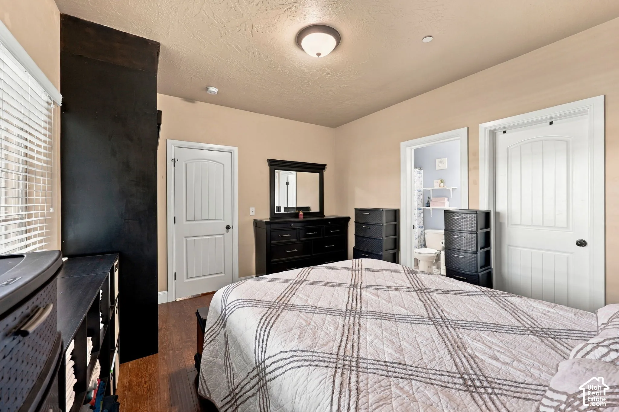 Wood-finish flooring, white paneled doors, and a ceiling-mounted light fixture