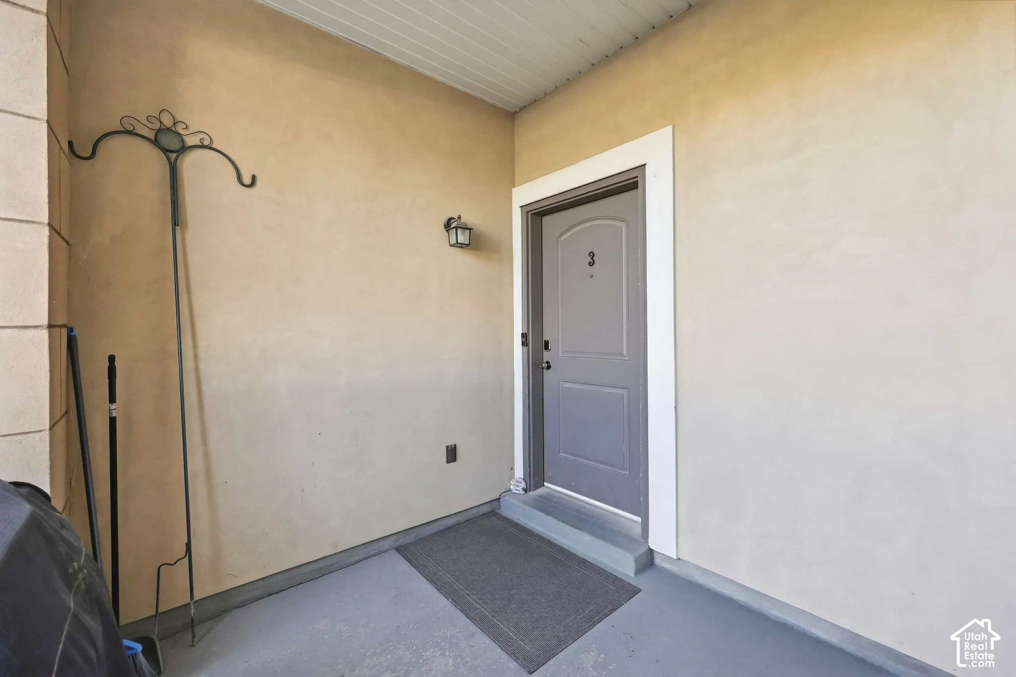 Private entrance featuring a paneled door, exterior wall sconce, and textured wall finish