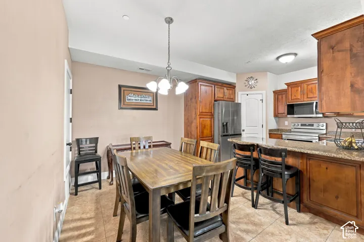 Kitchen featuring wood cabinetry, stainless steel appliances, a breakfast bar with seating, and granite countertops