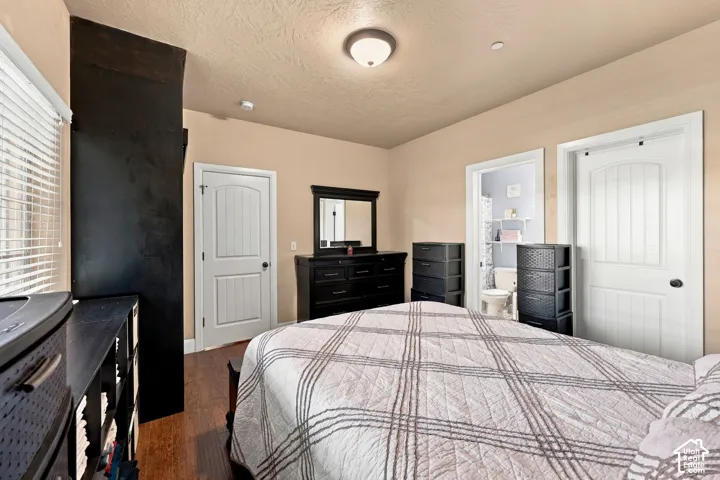 Wood-finish flooring, white paneled doors, and a ceiling-mounted light fixture