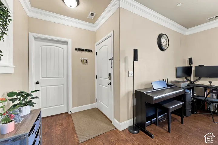 Wood-finish flooring throughout, crown molding, white doors with black hardware, and light-toned walls