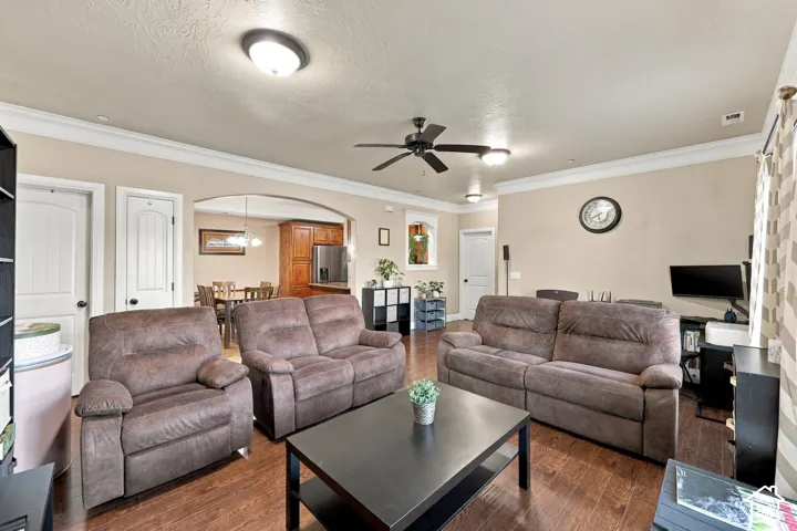 Recessed lighting, wood-finish flooring, a ceiling fan, and crown molding