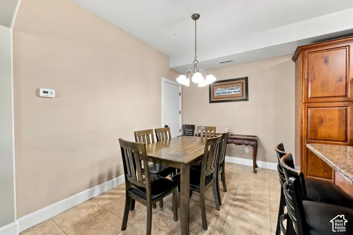 Tile flooring, recessed ceiling lighting, and a multi-light chandelier