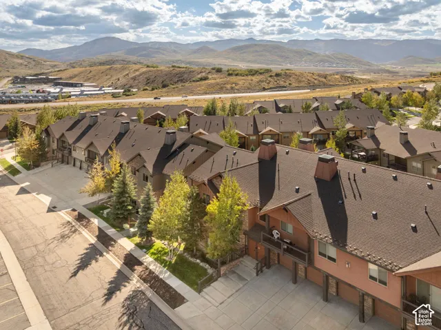 Townhome exterior featuring multiple balconies, sloped roofs, and a paved parking area