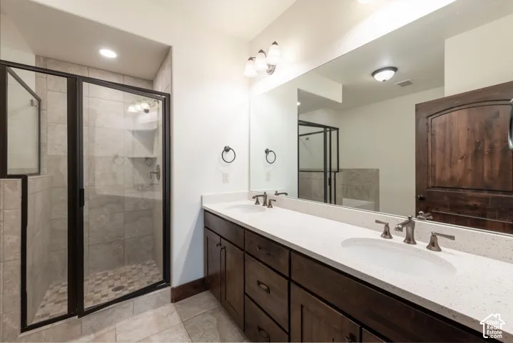 Dual vanity with undermount sinks, stone countertops, and dark wood-finish cabinetry