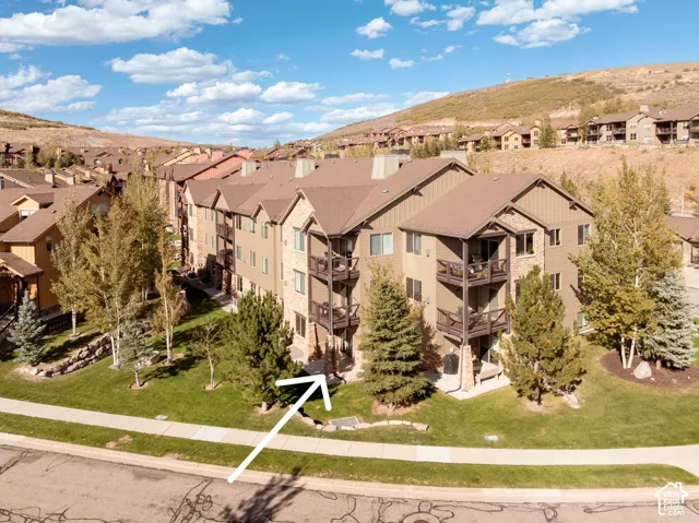 Multi-story building featuring stacked balconies, stone accents, and varied siding