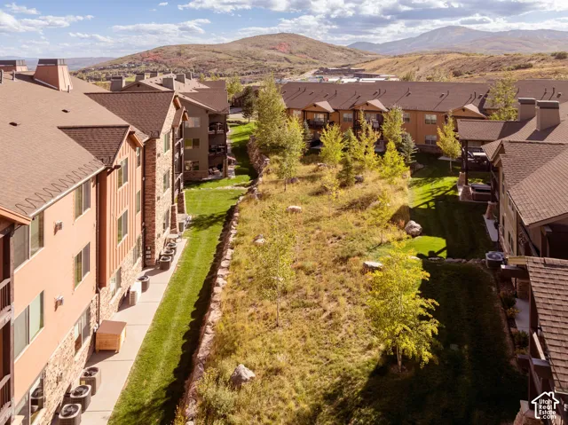 Sloped, landscaped terrain featuring natural rock elements and mature trees