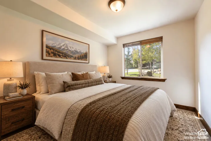 Recessed ceiling with an integrated light fixture, window with wood trim, and wood-finish baseboard