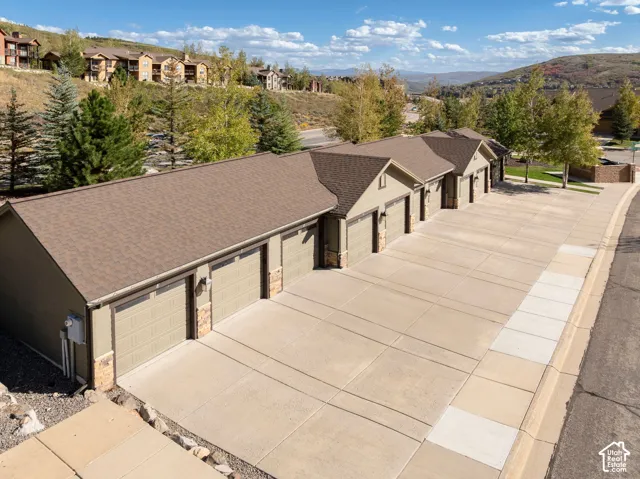 Row of attached garages with individual bay doors, stone accents, and a paved driveway