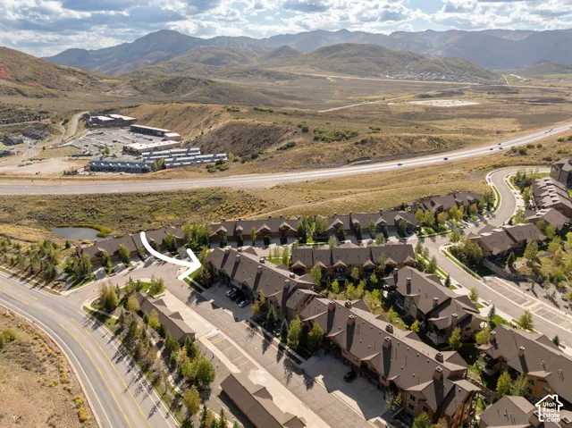 Community of properties with brown roofs, mature trees, and paved roads