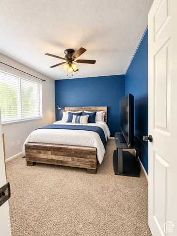 Wall-to-wall carpeting and a ceiling fan with integrated lighting