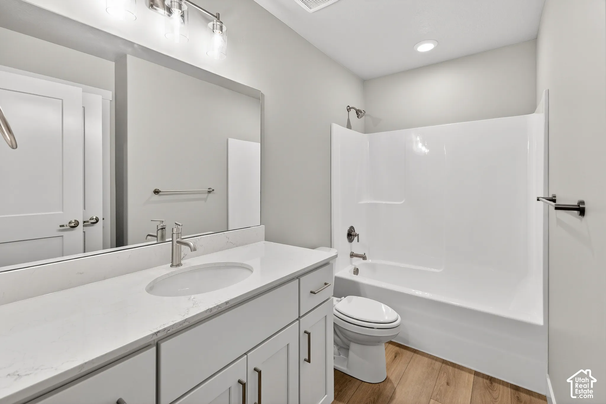 Vanity with a white countertop and undermount sink, brushed nickel faucet, and a large mirror