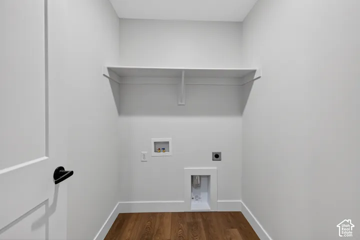 Dedicated utility space featuring wood-finish flooring, white walls, and a built-in shelf